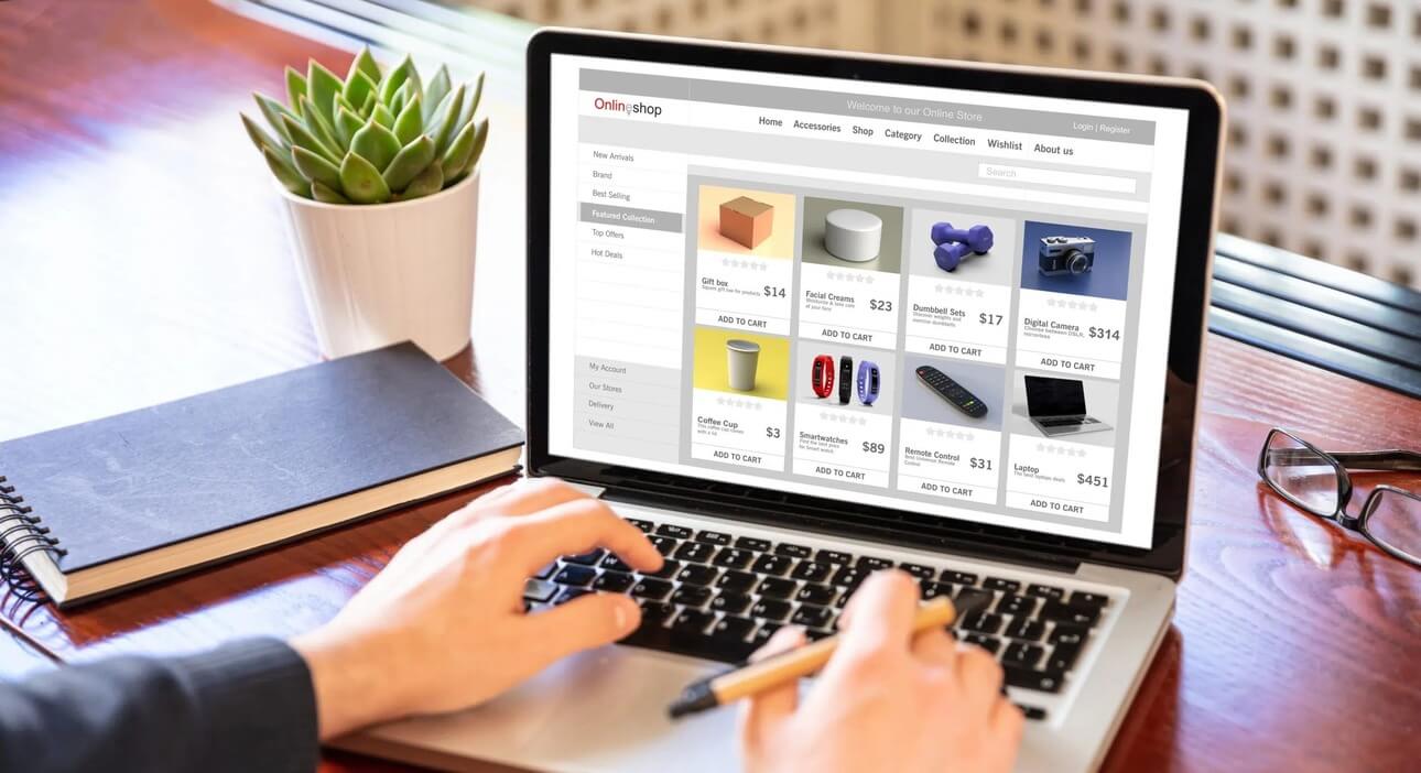 Person's hands typing on laptop in office shopping for ecommerce using top 11 shopify apps