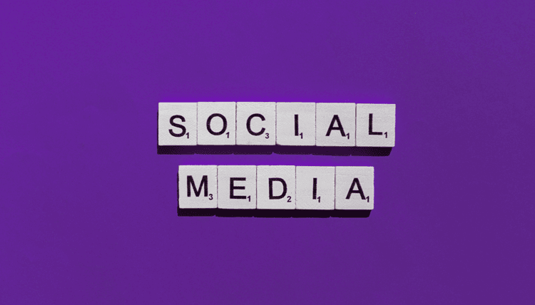 Scrabble tiles spelling out the word "social media" in a purple background